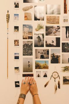 a person's hands are reaching up against a wall with many pictures on it