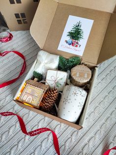 an open box filled with christmas gifts on top of a bed