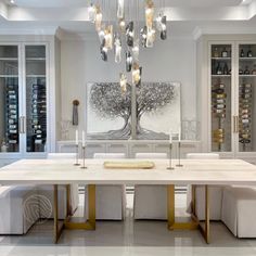 a dining room table with white chairs and chandelier