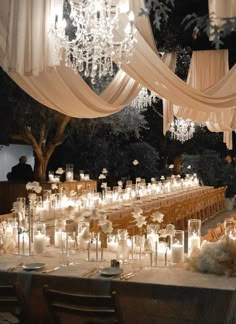 a long table is set up with candles and chandeliers