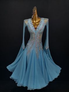 a blue ballroom dress with sequins and beads on the bodicet, in front of a black background