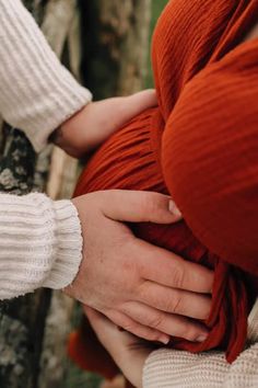 two people holding each other's hands while they are wrapped in red cloths