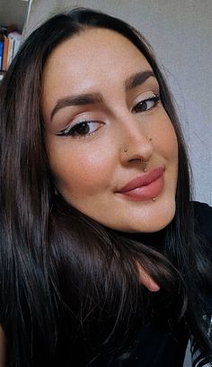 a close up of a person with long hair and brown eye shadow on her face