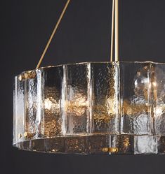 a chandelier made out of glass blocks hanging from a metal rod with two lights on each end