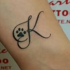 a dog's paw with a letter k tattoo on the wrist and foot area