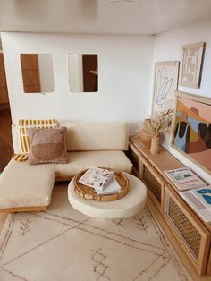 a living room filled with furniture and decor on top of a wooden floor next to a white rug