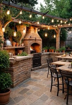 an outdoor kitchen with lights strung from the ceiling