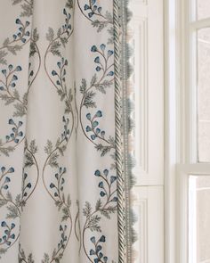 a curtain with blue flowers on it in front of a window