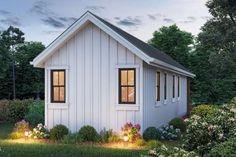 a small white house with windows and flowers in the front yard at dusk or dawn