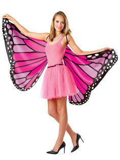 a woman in a pink dress with a butterfly wings on her back and legs, posing for the camera