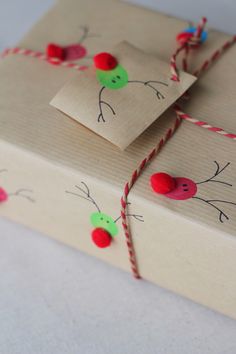 two wrapped gift boxes decorated with red and green buttons, twine and twine