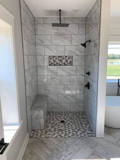 a walk in shower sitting next to a bath tub