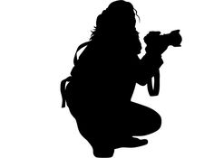 a woman kneeling down with a camera in her hand, silhouetted against a white background