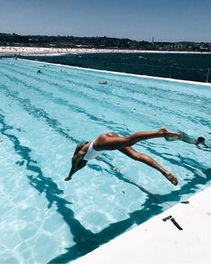 a woman diving into the water in a swimming pool