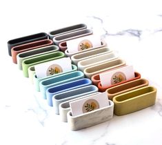 there are many different colored trays on the counter top, each with an individual's name