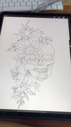 a tablet with a drawing of a skull and flowers on it