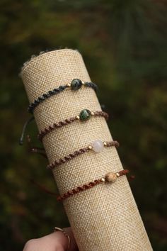 a hand holding a piece of cloth with different bracelets on it's arm