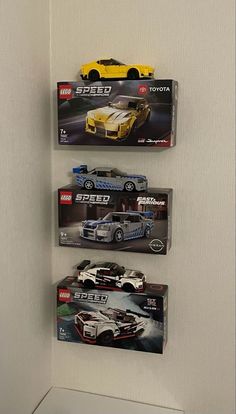 three lego cars are hanging on the wall