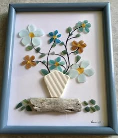 a shadow frame with flowers and a piece of driftwood