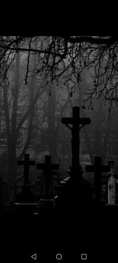 black and white photograph of a cemetery in the dark with tombstones on either side