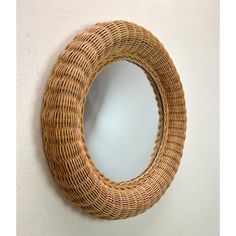 a round wicker mirror hanging on the wall