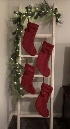 christmas stockings hung on a ladder with lights