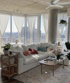 a living room filled with furniture and large windows