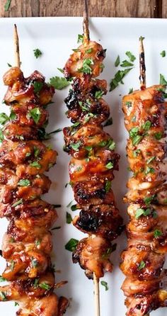 chicken skewers with cilantro and parsley on a white plate