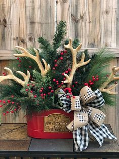 a potted plant with antlers, berries and pine cones in it sitting on a table