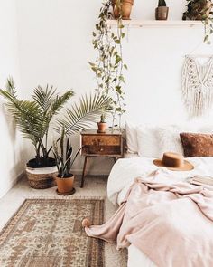 a bedroom with plants and rugs on the floor