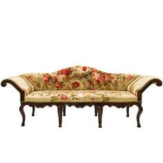 an old fashioned couch with floral fabric on it's back and arms, sitting in front of a white background