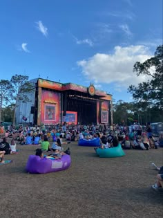 people sitting on bean bags in front of an outdoor stage