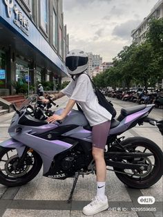 a person sitting on a motorcycle in the street