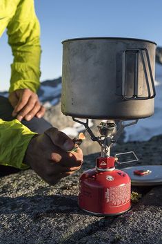 a man is setting up a fire extinguisher on top of a mountain