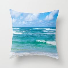 an ocean scene with waves crashing on the shore and clouds in the sky above it