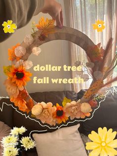 a person holding a fake wreath with flowers on it and the words dollar tree fall wreath