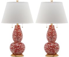 two red lamps sitting next to each other on top of a white table lamp shade