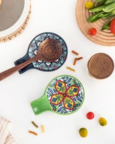 a wooden spoon sitting on top of a green plate next to other plates and bowls