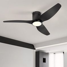 a black ceiling fan in a white room