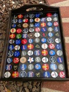 a box filled with lots of different types of beer bottle caps on top of a sidewalk