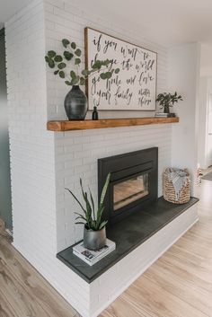 a living room with a white brick fireplace and potted plants on the mantel