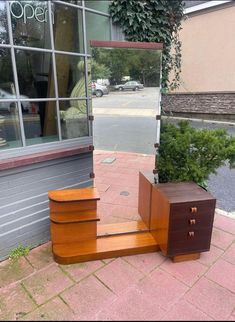 a set of stairs made out of wood sitting on the side of a building next to a window