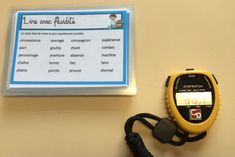 a yellow and black stopwatch sitting on top of a table next to a clipboard