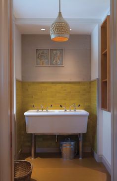 a bathroom with two sinks and a hanging light