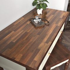 a wooden counter top sitting next to a potted plant on top of a hard wood floor