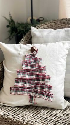 a christmas tree pillow sitting on top of a wicker chair