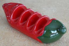 a red and green pepper sitting on top of a counter