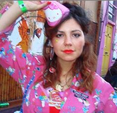 a woman in a pink shirt is holding a hello kitty hair dryer on her head