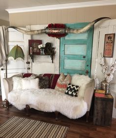 a living room with a couch, rugs and a blue door in the background