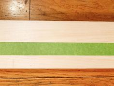 a piece of wood that has been painted green and white with a stripe on it